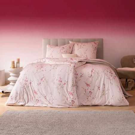 Pościel marki Estella Elsa w odcieniach pudrowego różu z motywem gałązek i kwiatów kwitnącej wiśni w sypialni.